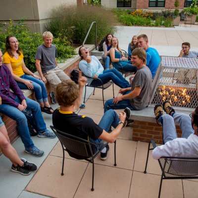 Students sitting around a firepit.