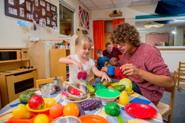 Teacher and student playing with colorful toys